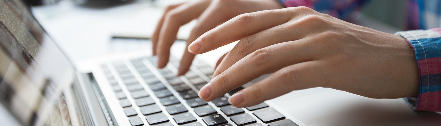cropped-view-hands-typing-laptop